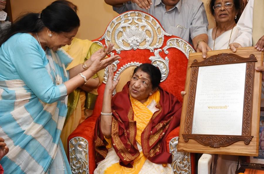 Lata Mangeshkar and Asha Bhosle share a moment at Lata Mangeshkar's felicitation by the Karvir Pith Shankaracharya at Prabhu Kunj. Bharat Ratna Lata Mangeshkar,Lata Mangeshkar,Swara Mauli award,Swara Mauli,Lata Mangeshkar Swara Mauli award