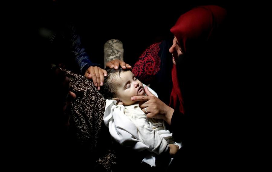 Eight-month-old Palestinian infant Laila al-Ghandour died from tear gas that her family said she inhaled at a protest camp near the border Israel-Gaza border. A relative mourns as she carries the body of eight-month-old Palestinian infant Laila al-Ghandour, who died after inhaling tear gas during a protest against U.S embassy move to Jerusalem at the Israel-Gaza border, during her funeral in Gaza City May 15, 2018. Palestinian baby,border protest,Palestinian border protest,Israel-Gaza border,Laila al-Ghandour