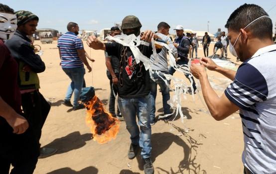 Israeli soldiers use drones to down flaming kites that Palestinian protesters are flying over the border in a bid to torch bushes and distract snipers. Palestinian demonstrators prepare to set a kite on fire to be thrown at the Israeli side during a protest demanding the right to return to their homeland, at the Israel-Gaza border in the southern Gaza Strip, May 11, 2018.