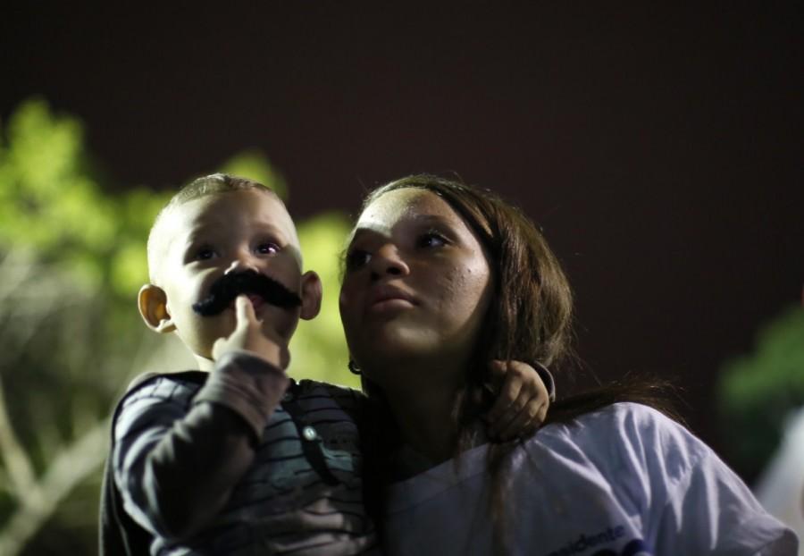 A young supporter wears a mustache depicting Venezuela's President Nicolas Maduro while he speaks during a gathering after the results of the election were released, outside of the Miraflores Palace in Caracas, Venezuela, May 20, 2018. Nicolas Maduro,President Nicolas Maduro,Nicolas Maduro re-elected