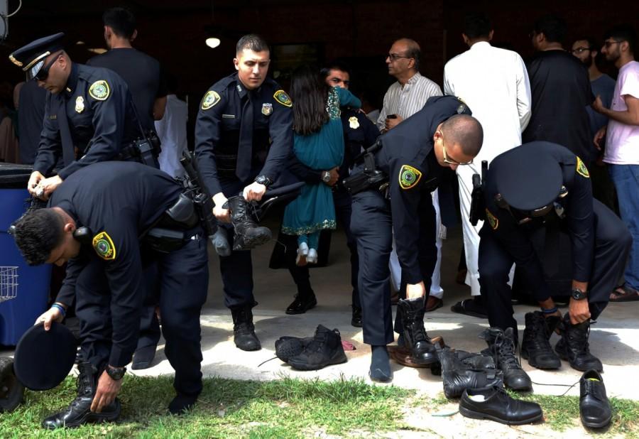 Houston police officers put their shoes back on following a funeral prayer service for Sabika Sheikh at the Brand Lane Islamic Center in Stafford, Texas, U.S., May 20, 2018. Funeral for Pakistani student,Pakistani student,Texas school shooting,Texas shooting,texas shooting incident,Texas shooting 26 killed,South Texas shooting