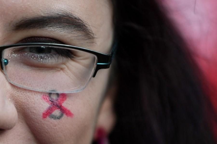 A demonstrator shows a symbol for Repeal the 8th Amendment painted on her face during a march for more liberal Irish abortion laws, in Dublin, Ireland. Abortion referendum,Pro-Choice mural,abortion law,Ireland