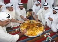 Members of the opposition use their hands to eat an Iftar dish of cooked lamb during a breaking-fast dinner at sundown, during the first day of Eid al-Adha in al-Arada Square (Determination Square), a grassy area in front of Parliament in Kuwait City. The Kuwaiti government has banned gatherings of more than 20 people anywhere in Kuwait except al-Arada Square.