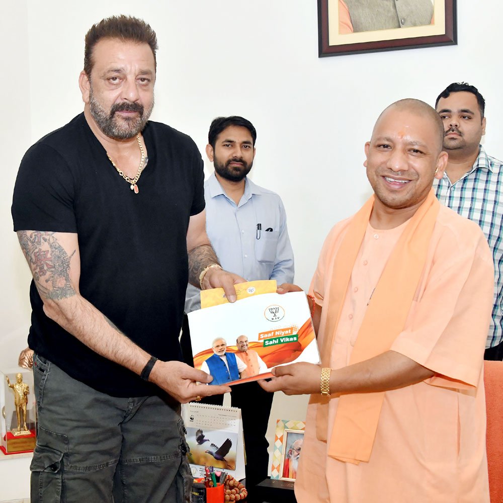 Uttar Pradesh Chief Minister Yogi Adityanath on Saturday met Bollywood actor Sanjay Dutt to discuss 'Sampark for Samarthan' (contact for support), a personal outreach programme to highlight the achievements of the Narendra Modi-led government in the last four years. Adityanath shared a photograph in which he is seen presenting a booklet featuring Prime Minister Narendra Modi and Bharatiya Janata Party (BJP) President Amit Shah on the cover. "Thank you Yogi Adityanathji for making me a part of 'Sampark for Samarthan' initiative. It's indeed an honour," Sanjay tweeted. The campaign is a part of the party's effort to reach out to maximum number of people ahead of the 2019 Lok Sabha polls. BJP launched the contact programme after completing four years of the NDA rule at the Centre. About 4,000 senior party workers, including Union Ministers, Chief Ministers and Deputy Chief Ministers of states, are to carry out the campaign to meet more than one lakh well-known personalities. Shah had earlier called on Bollywood actress Madhuri Dixit-Nene and her doctor-husband Shriram Nene. Yogi Adityanath,CM Yogi Adityanath,Sanjay Dutt,Yogi Adityanath meets Sanjay Dutt,Sampark for Samarthan,Sampark for Samarthan campaign