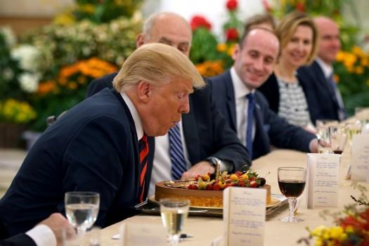 U.S. President Donald Trump blows out the candle on his birthday cake as he attends a lunch with Singapore's Prime Minister Lee Hsien Loong at the Istana in Singapore June 11, 2018.