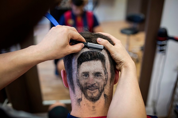 Serbian hairdresser Mario Hvala creates a hair tattoo showing the portrait of Argentinian football player Lionel Messi on the head of a football fan in Novi Sad, Serbia, on June 10, 2018. - A Serbian hairdresser proposes to his clients to draw with scissors on the back of their heads portraits of football superstars Lionel Messi and Cristiano Ronaldo for the forthcoming World Cup in Russia. Mario Hvala gives his creativity free rain ever since, 18 years ago, he made with scissors a tarantula on a client's head after suggesting him: 'Let's do something different.' For the World Cup, which opens on June 14, 2018, he proposes to football afficionados to do the same thing with Messi and Ronaldo. FIFA World Cup fans,FIFA World Cup,Lionel Messi,Lionel Messi fans,Messi fans,Lionel Messi headshot,Messi headshot