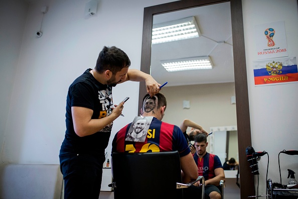 Serbian hairdresser Mario Hvala creates a hair tattoo showing the portrait of Argentinian football player Lionel Messi on the head of a football fan in Novi Sad, Serbia, on June 10, 2018. - A Serbian hairdresser proposes to his clients to draw with scissors on the back of their heads portraits of football superstars Lionel Messi and Cristiano Ronaldo for the forthcoming World Cup in Russia. Mario Hvala gives his creativity free rain ever since, 18 years ago, he made with scissors a tarantula on a client's head after suggesting him: 'Let's do something different.' For the World Cup, which opens on June 14. FIFA World Cup fans,FIFA World Cup,Lionel Messi,Lionel Messi fans,Messi fans,Lionel Messi headshot,Messi headshot