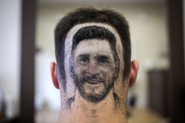 A football fan sports a hair tattoo showing the portrait of Argentinian football player Lionel Messi at a hair salon in Novi Sad, Serbia, on June 10, 2018. - A Serbian hairdresser proposes to his clients to draw with scissors on the back of their heads portraits of football superstars Lionel Messi and Cristiano Ronaldo for the forthcoming World Cup in Russia. Mario Hvala gives his creativity free rain ever since, 18 years ago, he made with scissors a tarantula on a client's head after suggesting him: 'Let's do something different.' For the World Cup, which opens on June 14, 2018. FIFA World Cup fans,FIFA World Cup,Lionel Messi,Lionel Messi fans,Messi fans,Lionel Messi headshot,Messi headshot