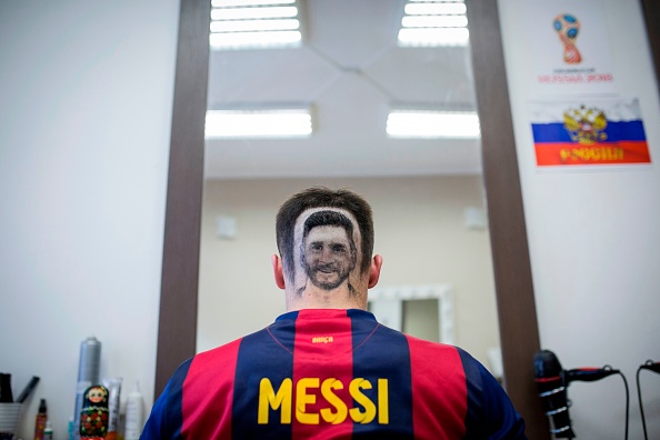 A football fan sports a hair tattoo showing the portrait of Argentinian football player Lionel Messi at a hair salon in Novi Sad, Serbia, on June 10, 2018. - A Serbian hairdresser proposes to his clients to draw with scissors on the back of their heads portraits of football superstars Lionel Messi and Cristiano Ronaldo for the forthcoming World Cup in Russia. Mario Hvala gives his creativity free rain ever since, 18 years ago, he made with scissors a tarantula on a client's head after suggesting him: 'Let's do something different.' For the World Cup, which opens on June 14, 2018, he proposes to football afficionados to do the same thing with Messi and Ronaldo. FIFA World Cup fans,FIFA World Cup,Lionel Messi,Lionel Messi fans,Messi fans,Lionel Messi headshot,Messi headshot