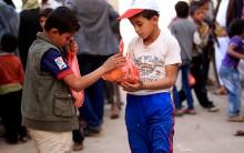 Yemeni children receive free food rations among five hundred families, recipients of an initiative by local youths during the holy month of Ramadan in the capital Sanaa on May 27, 2018.