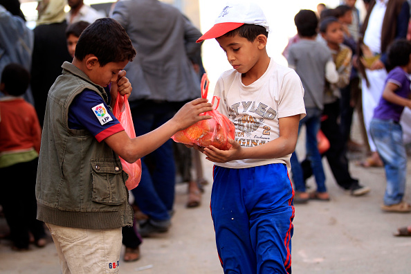 Yemeni children receive free food rations among five hundred families, recipients of an initiative by local youths during the holy month of Ramadan in the capital Sanaa on May 27, 2018. Ramadan 2018,Ramadan,Iftar meals,Ramzan Id,Eid-ul-Fitar,Eid-ul-Fitar 2018,Ramadan meals