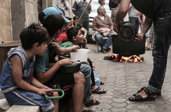 Palestinian children wait to receive free soup during the holy month of Ramadan, in Gaza City on May 27, 2018. Ramadan 2018,Ramadan,Iftar meals,Ramzan Id,Eid-ul-Fitar,Eid-ul-Fitar 2018,Ramadan meals