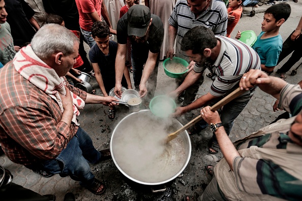 Palestinian national Waleed el-Hattab (L) cooks a soup prior to distribute it to the needy during the holy month of Ramadan, in Gaza City on May 27, 2018. Ramadan 2018,Ramadan,Iftar meals,Ramzan Id,Eid-ul-Fitar,Eid-ul-Fitar 2018,Ramadan meals