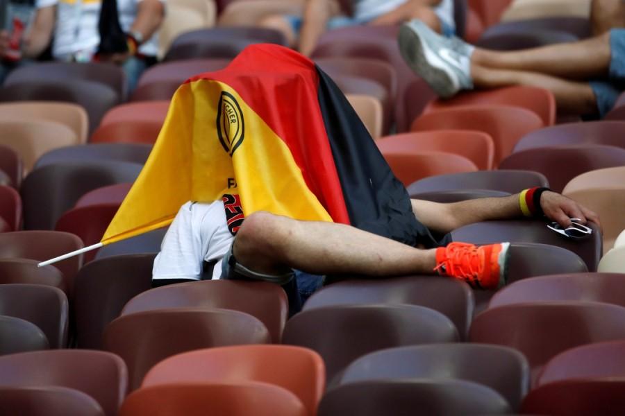 Germany fan covers their face with a flag in dejection after the match. FIFA World Cup 2018,FIFA World Cup,2018 FIFA World Cup,Germany fans,germany football team,Germany and Mexico,Mexico