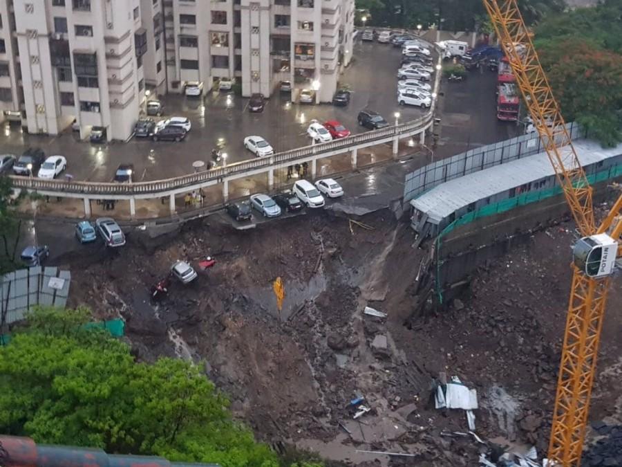 A portion of the wall of an under-construction highrise at Lords Estate in Antop Hill trapping many residents and damaging over a dozen private cars parked in a neighbouring society premises. Mumbai rains,mumbai rains update,Mumbai rains pics,Mumbai rains images,Mumbai rains stills,Mumbai traffic,Mumbai wall collapses