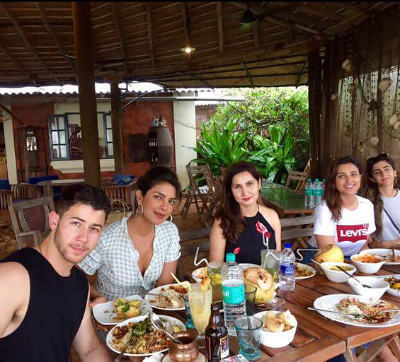 Priyanka Chopra's recent Goa vacation with family and friends, including Nick Jonas, has grabbed the eyeballs of many. Social media is buzzing with pictures of the rumoured couple's beach holiday. In one still, PeeCee and Nick can be seen sitting next to each other and having a meal with Parineeti Chopra and others. The 'Namaste England' star also took to Twitter to share a fun video with sissy Priyanka. "Not a cheesy chopra sister performance. Nope. @priyankachopra #DancingInTheRain," she captioned the clip. Nick Jonas,Nick Jonas selfies with Priyanka,Priyanka Chopra,Parineeti Chopra,Nick Jonas and Priyanka Chopra,Nick Jonas and Priyanka Chopra in Goa,Nick Jonas and Priyanka Chopra pics,Nick Jonas and Priyanka Chopra images