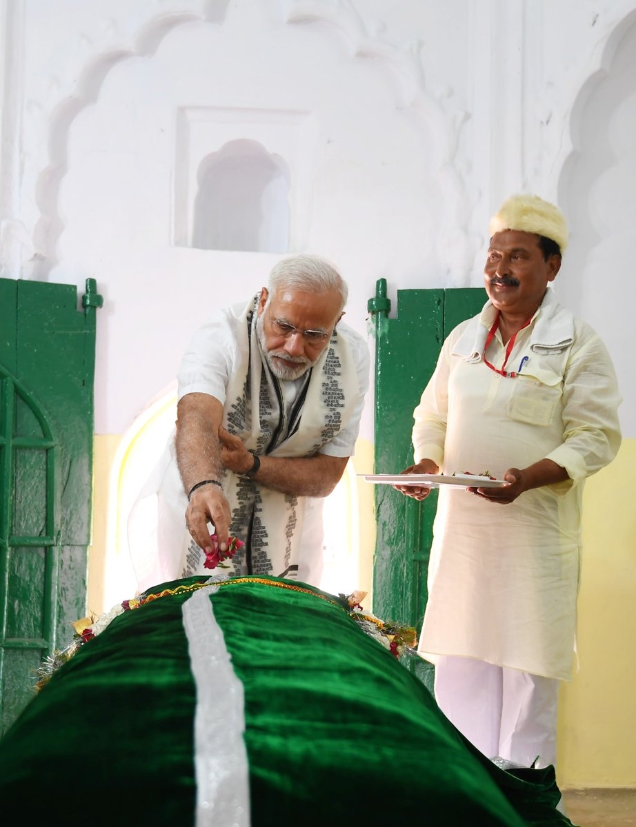 Prime Minister Narendra Modi on Thursday offered floral tributes at the 'samadhi' and 'mazaar' of the 15th-century saint Kabir Das at Maghar in Sant Kabir Nagar district in Uttar Pradesh. Modi became the first Prime Minister to visit Maghar, where the mystic poet and saint breathed his last in 1518. Dressed in white kurta and choodidaar payjama, the Prime Minister was flanked by the saffron-robed Uttar Pradesh Chief Minister Yogi Aditytanath and priests at the shrine as he took a round of the place. He was gifted a 'angawastra' and some literature on the saint. Officials present with the Chief Minister told IANS that Modi took keen interest in knowing the details of Maghar even as he surprised many with his in-depth knowledge of the saint who is revered equally by Hindus and Muslims. Modi pays tributes to Kabir Das,Kabir Das,Modi in Maghar,Narendra in Maghar,saint Kabir Das,Sant Kabir Nagar