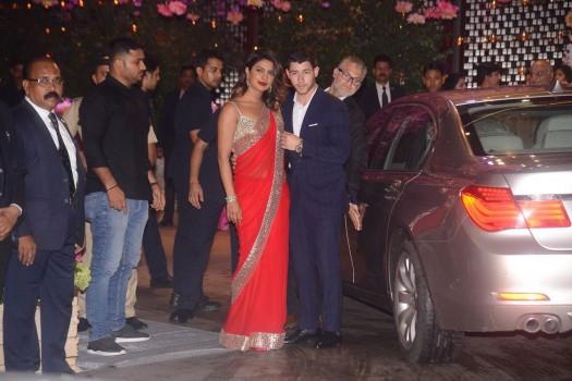Priyanka Chopra turned heads as she arrived with rumoured beau, Nick Jonas at Nita and Mukesh Ambani's star-studded party, hosted for their son Akash and his fiancee Shloka Mehta in Mumbai. The rumoured couple, who have been making public appearance together lately, made an entry at the venue and also posed for the cameras. Priyanka wore a bright red sari from the studios of Abu Jani and Sandeep Khosla and paired it with a golden blouse, bracelet and a pair of earrings. While Nick complimented her in a blue suit.