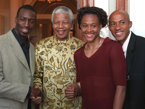 American sprinters Michael Johnson (L) and Marion Jones (second from R) clasp South African President Nelson Mandela's hands, while Namibian sprinter Frankie Fredericks (R) peers over Marion Jones's shoulder at the President's home Genadendal in Cape town 25 March. The three athletes will be competing in the Engen Grand Prix Summer Series track and field meeting to be held in the city 26 March. Nelson Mandela 100th birthday,Nelson Mandela birthday,Nelson Mandela rare pics,Nelson Mandela rare images,Nelson Mandela rare stills,Nelson Mandela rare pictures,Nelson Mandela rare photos,Nelson Mandela unseen pics,Nelson Mandela unseen images,Nelson Man