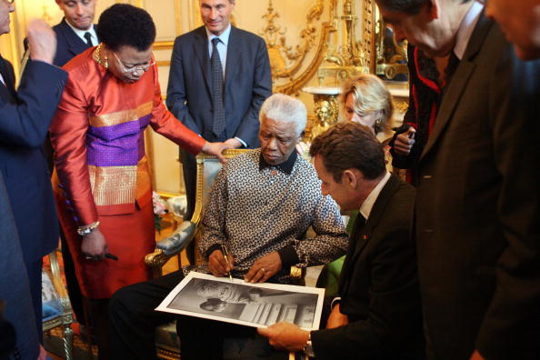 Former South African president Nelson Mandela (C) signs a picture to French President Nicolas Sarkozy (R) next to his wife Graca Machel (R) during a meeting, 04 September 2007 at the Elysee palace in Paris. The 89-year-old Nobel Peace Prize winner Mandela spent 27 years in prison before being freed in 1990, going on to become South Africa's first black leader in 1994 after the fall of apartheid. He received last week a hero's welcome in London, where a statue of him was unveiled opposite the Houses of Parliament. Nelson Mandela 100th birthday,Nelson Mandela birthday,Nelson Mandela rare pics,Nelson Mandela rare images,Nelson Mandela rare stills,Nelson Mandela rare pictures,Nelson Mandela rare photos,Nelson Mandela unseen pics,Nelson Mandela unseen images,Nelson Man