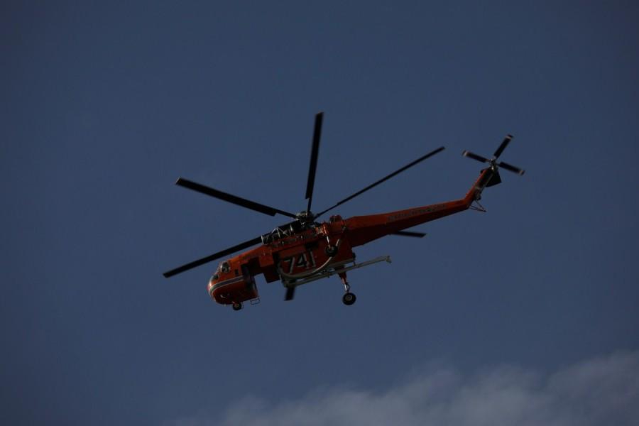 Helicopter flies over a wildfire Athens wildfire,Athens fire,Athens wildfire pics,Athens wildfire images,Greek capital,Orange smoke,Wildfire rages near Athens