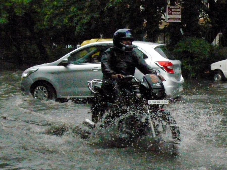 A motorcyclist wades through water logged street after a heavy downpour in New Delhi Heavy rain,Heavy rain in Delhi,Delhi rains,National Capital Region