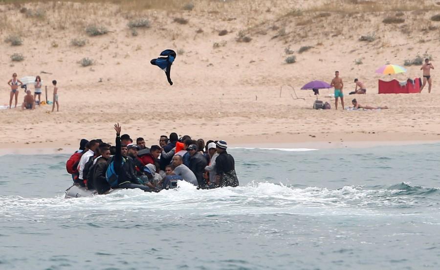 Migrants land on Spanish beach, flee as tourists look on Boat full of migrants,Spanish beach,migrants on Spanish beach,30 illegal migrants