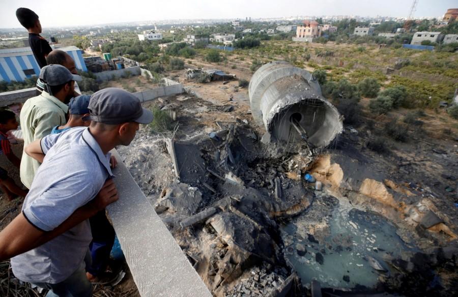 Palestinians look at damage at the site of an Israeli air strike in Al-Mughraqa Israeli aircraft struck,Israeli aircraft,Israeli airstrikes Gaza,Gaza,Palestinian militants,Israel attacks Gaza
