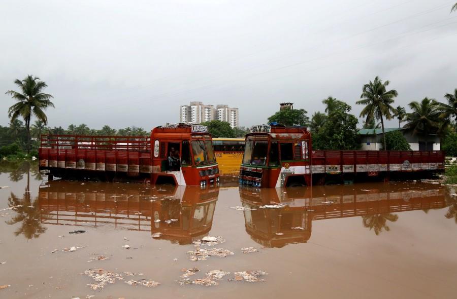 Partially submerged trucks are seen surrounded by floodwaters at a parking bay Kerala floods,Kerala floods pics,Kerala floods images,Kerala floods stills,Kerala floods pictures,Kerala floods photos,Kerala worst flood