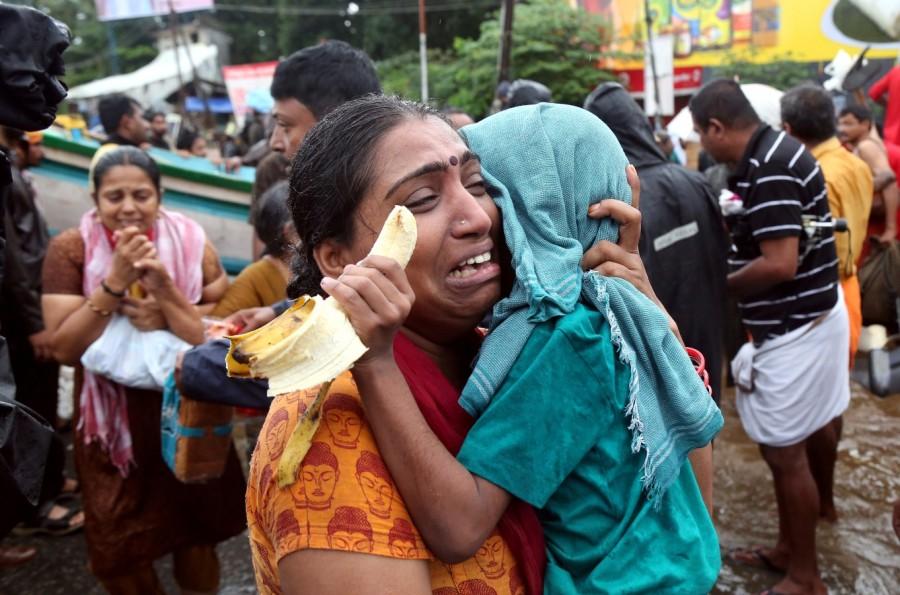 A woman cries as she holds her son Kerala floods,Kerala floods pics,Kerala floods images,Kerala floods stills,Kerala floods pictures,Kerala floods photos,Kerala worst flood
