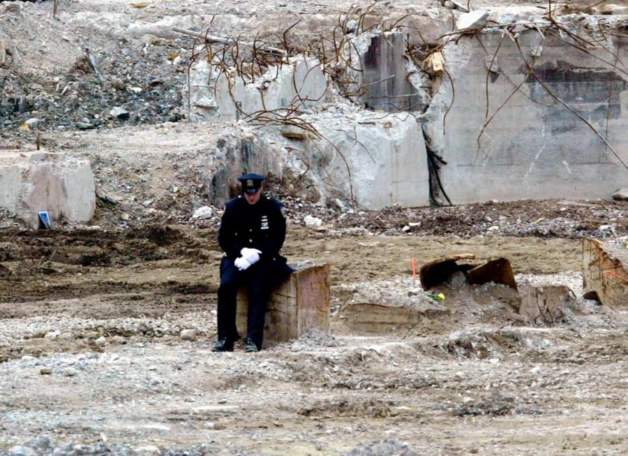 A lone police officer sits away from where family members of the victims World Trade Center,World Trade Center attack,September 11 attack,Twin Towers attack,pentagon attack,9/11,9/11 pictures,World Trade Center attack pictures,powerful post attack pictures,United States,hijacked airplane,New York City,Pentagon building,north t