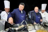 Russian President Vladimir Putin and Chinese President Xi Jinping make pancakes