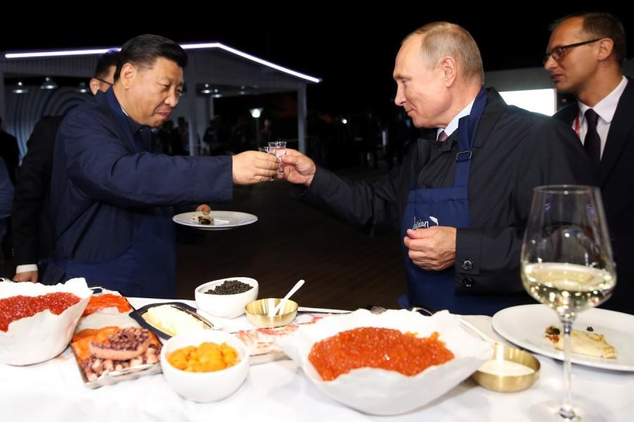 Russian President Vladimir Putin and Chinese President Xi Jinping toast during a visit to the Far East Street exhibition Russian President Vladimir Putin,Vladimir Putin,Chinese prez Xi Jinping,Xi Jinping,Vladimir Putin,Xi Jinping turn chefs,Vladimir Putin turns chefs,Xi Jinping turns chefs