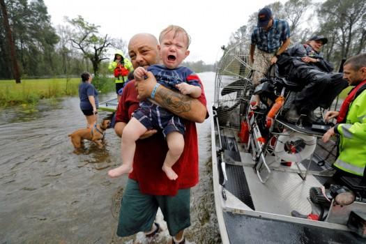 Oliver Kelly, 1 year old, cries as he is carried off the sheriff's airboat